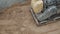 Slowmotion working petrol yellow plate compactor compressing sand surface