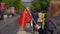 Slowmotion of a young woman bloger holding a small Chinese flag walk the Quinmen Main Street Mall. The Forbidden City in