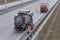 Sludge washer truck suction machine and workers specialists at work on the side of the highway to clean underground infrastructure