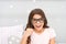 Slumber party photo booth props. Kid girl cheerful posing with vintage black eyeglasses party attribute. Prepare photo