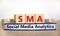 SMA social media analytics symbol. Wooden cubes on book with word `SMA social media analytics` on beautiful white background, co