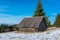 Small abandoned wood house at wintertime on the top of the mountain