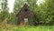 Small abandoned wooden house in the village among the greenery in summer.