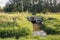 Small adjustable metal weir reflects in the mirror smooth water