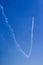 Small airplane leaving a trail of smoke with the blue sky in the background