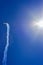 Small airplane leaving a trail of smoke with the blue sky in the background