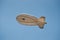 Small airship flying in blue sky