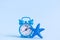 Small alarm clock and sea star isolated on blue. Summer vacation minimal concept. Space for copy.