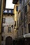 Small alley, with the facade of a historic frescoed building and a large garden, in Verona.