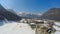 Small Alpine resort town at lakeside, huge mountains, snowy peaks, fast motion
