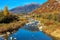 Small alpine river and colorful autumnal mountains in Switzerland.