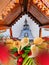 small altar with a metal statue of Buddha and flowers offerings