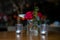 small amount of red roses in glass as decoration with candles next to