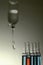 Small ampoule among big ampoules with intravenous drip in the background. Conceptual image