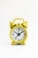 Small analogue yellow golden clock in isolated white background