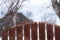 Small angry bullfinch on the fence chases other birds away from food. male. protection of the territory