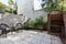 Small apartment courtyard with paving and cane outdoor chairs