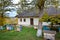 Small apiary with colorful hives in a yard of traditional old country house, cloudy autumn day, green ecological tourism