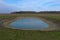 Small artificial shallow reservoir. A beautifully colored pond. Spring landscape