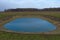 Small artificial shallow reservoir. A beautifully colored pond. Spring landscape