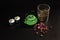 A small Asian type green cast iron teapot along with dry tea in a glass bowl, porcelain cups and rosebuds