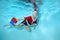 A small athletic boy swims underwater in a pool in a Santa Claus costume. Swimming classes. Healthy lifestyle. The