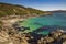 Small Atlantic beach with turquoise blue, crystal clear water, fine sand and rocks. O Corvo beach. Lighthouse trail