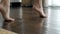 Small attractive foot are on dark brown wooden parquet.