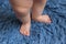 Small baby feet doing the first step on the blue carpet