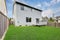 Small back yard with green grass and wooden fence