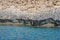 Small backwater surrounded by a stone cliff with azure water in Cyprus