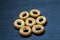 Small bagels on a dark wooden background.