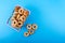 Small bagels in a metal shopping basket on blue background.