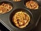 Small baked pecan pies in metal baking tin