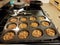 Small baked pecan pies in metal baking tin in kitchen