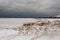 Small balls of ice and sand littered on top of large blocks of snow and ice on Lake Michigan on gloomy overcast day