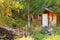 Small barn or house in colorfull autumn forest.