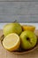 Small basket with fruits. Apples, lemons, carrot on the table.