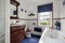 Small bathroom decorated in white with blue blind and mahogany sink unit