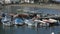 Small bay with docked speedboats, fishing nets lying on mooring, seaside village