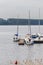 Small bay full of boats and ferries at coast of big lake at sunny morning