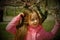 A small, beautiful girl in pink clothes walking in the Park near a flowering tree