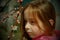 A small, beautiful girl in pink clothes walking in the Park near a flowering tree