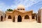 Small beautiful neat stone clay Arab Islamic Muslim houses with round domes in the desert with palm trees in a tropica