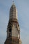 A small beautifully decorated tower of a Buddhist temple on a background of blue sky