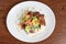 Small beef medallions with bell pepper, orange, red grapes and lettuce decorated with dill and parsley