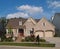 Small Beige Brick Home with Two Car Garage in Fron