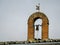 Small bell, cross and old weather vane on a roof