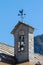 Small belltower of an old mountain church weather on the