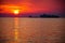 Small and big container tanker ship silhouette parked in a bay with a beautiful sunset sky